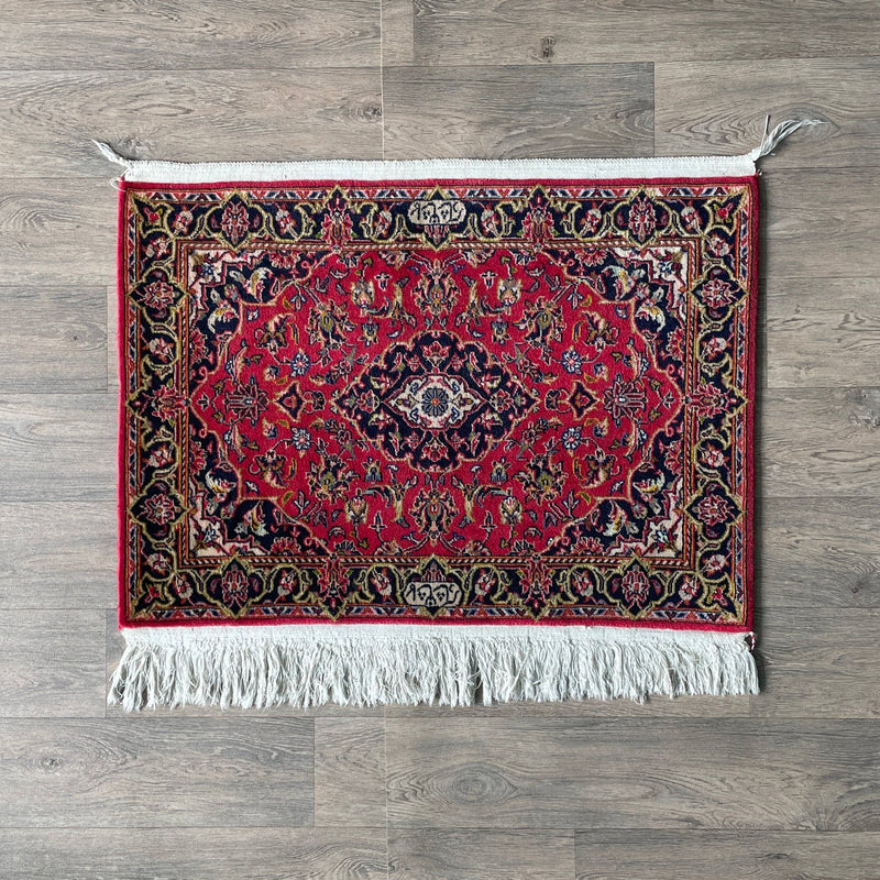 Authentic Persian Kashan rug with a traditional central Shah Abbasi medallion, intricate red and navy blue floral curvilinear patterns, woven with premium wool.