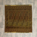 Handmade Afghan brown Mushwani tribal rug featuring a unique combination of flat-weave kilim and raised wool pile geometric diamond patterns, displayed on a light oak wood floor.