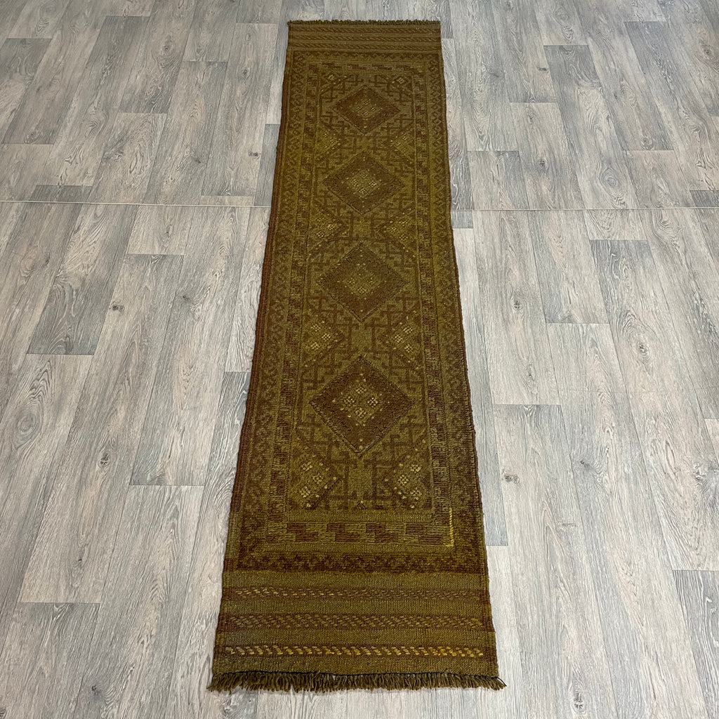 Handmade Afghan brown Mushwani tribal runner rug featuring a textured combination of flat-weave kilim and raised wool pile geometric diamond patterns, running along a light oak wood floor
