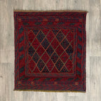 Handmade square Afghan brown Mushwani tribal rug featuring a unique combination of flat-weave kilim and raised wool pile geometric diamond patterns, displayed on a light oak wood floor.