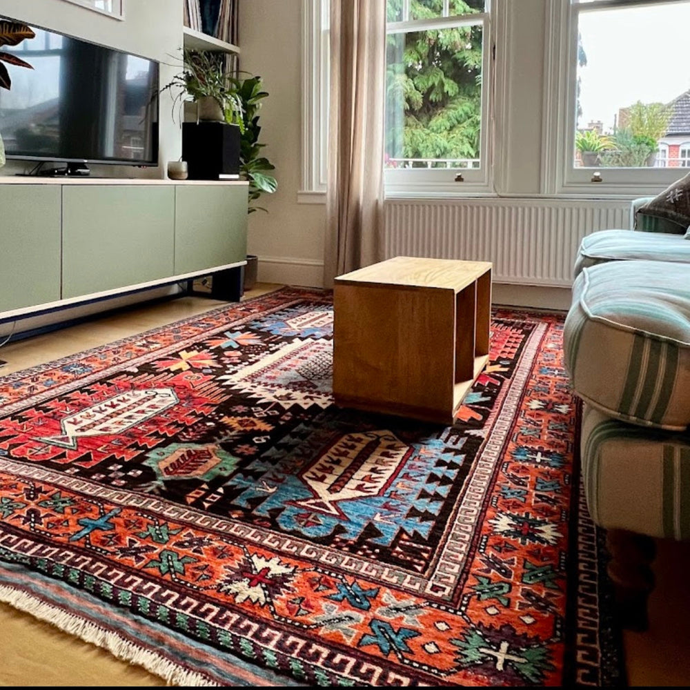 Living room with a large patterned rug, sofa, coffee table, and television.