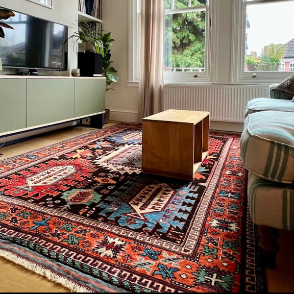 Living room with a large patterned rug, sofa, coffee table, and television.