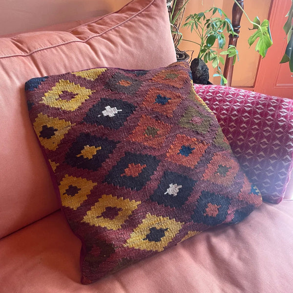 Decorative Kilim cushion with geometric pattern on a pink couch